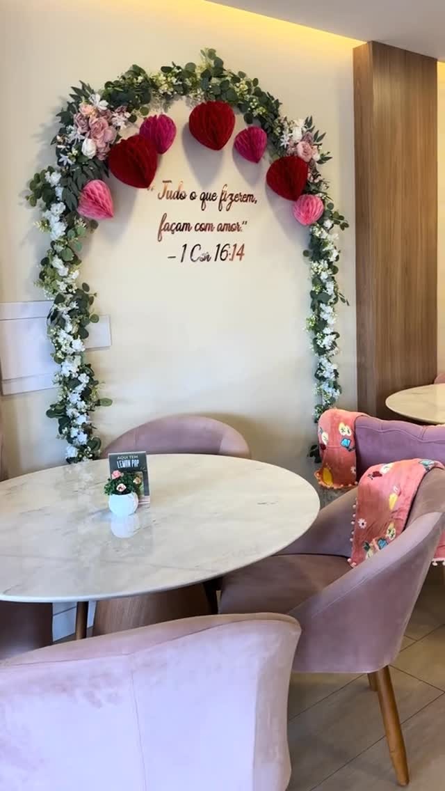 Ambiente da confeitaria com arco floral e poltronas